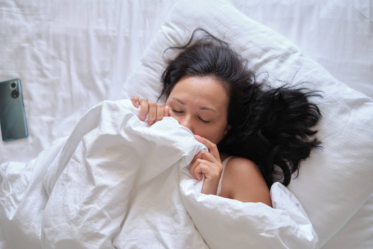 Lying in white sheets, tranquility personified. Echoes the real-world need for relaxation amidst the chaos, contrasting with AI-generated perfection.