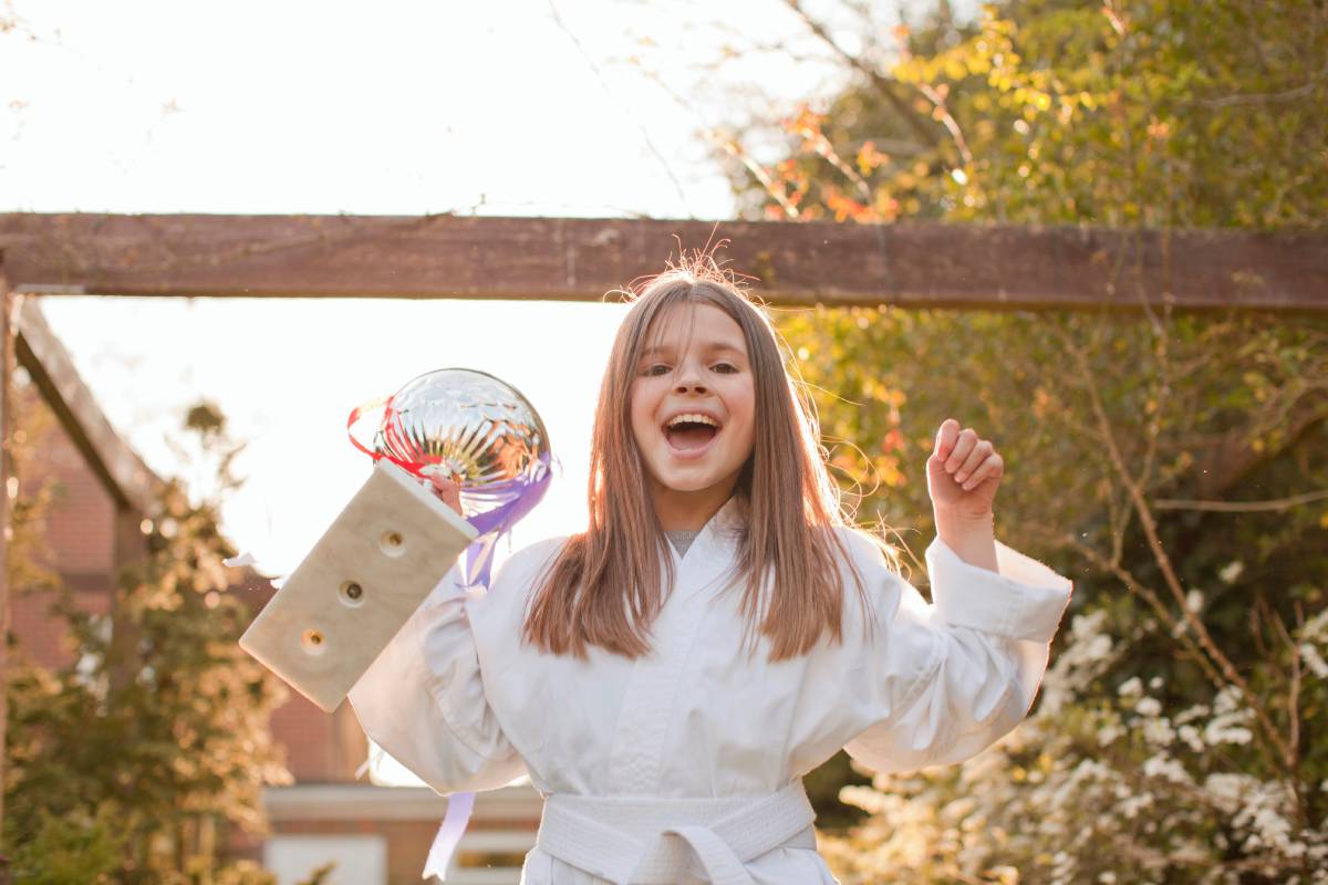 portrait-of-girl-celebrating-trophy-in-garden-2024-12-13-20-24-54-utc (1)