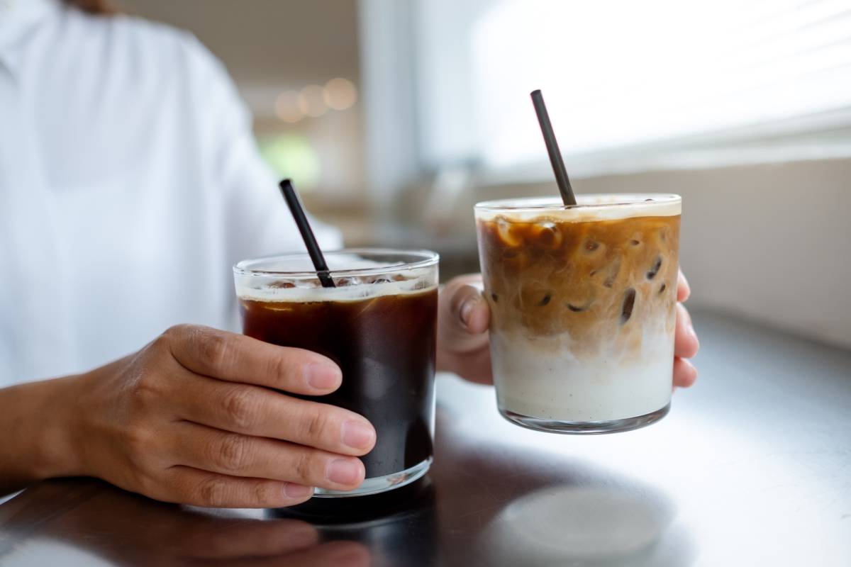 Closeup of a woman holding two glasses of iced coffee