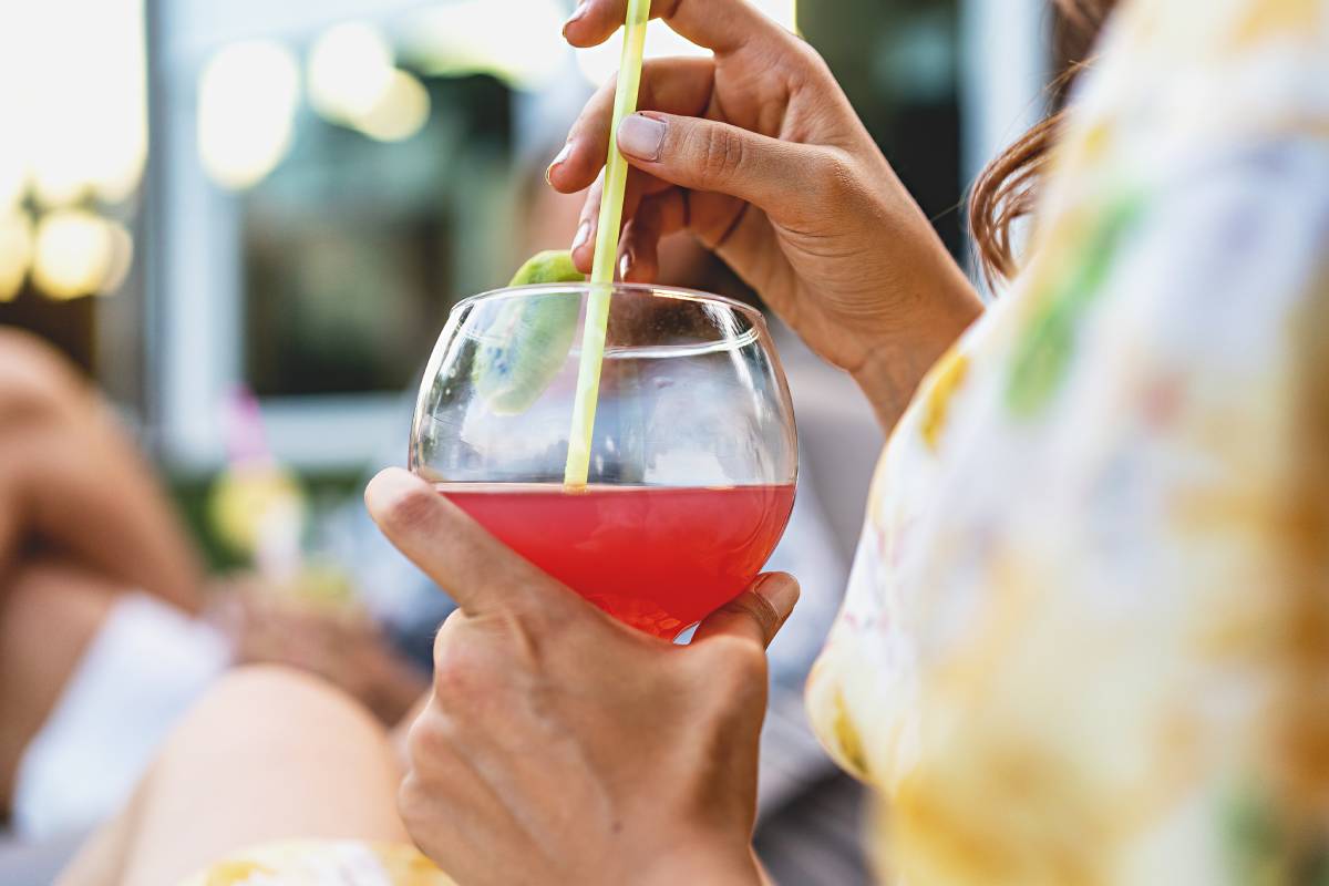 Woman sitting outdoors and drinking a cocktail