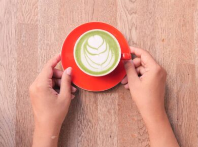 matcha latte in a red color cup on table