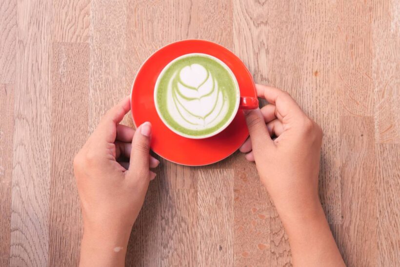 matcha latte in a red color cup on table