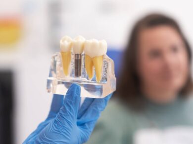 close-up patient dental implant treatment plan. The focus is teeth implant model in dentists hand