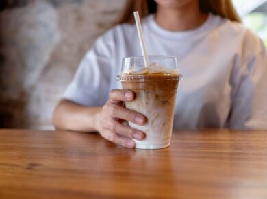 Closeup image of a young woman holding a glass of iced coffee