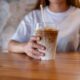 Closeup image of a young woman holding a glass of iced coffee