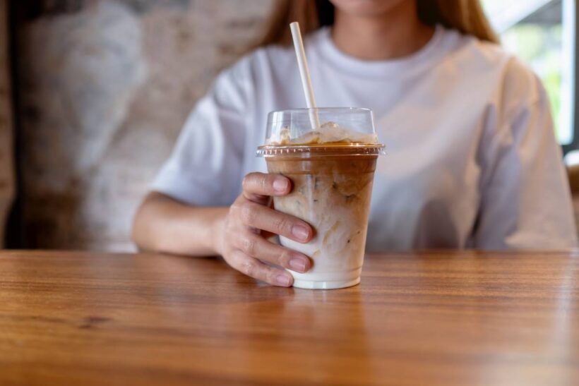 Closeup image of a young woman holding a glass of iced coffee