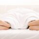 Relationship crisis. Bare feet of couple sleeping separately in bed, free space